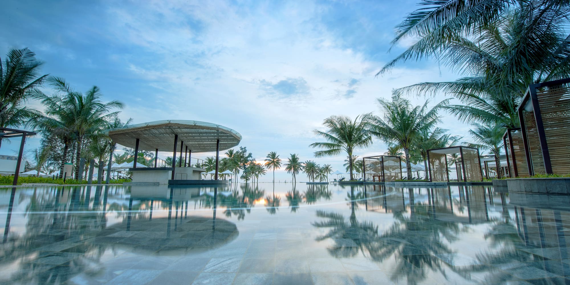 a pool with palm trees and a gazebo