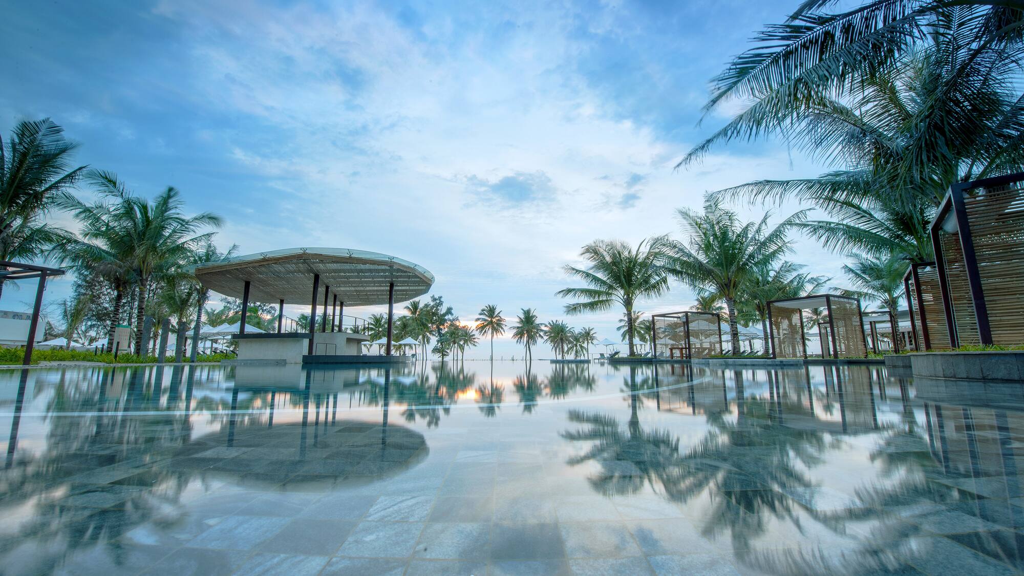 a pool with palm trees and a gazebo