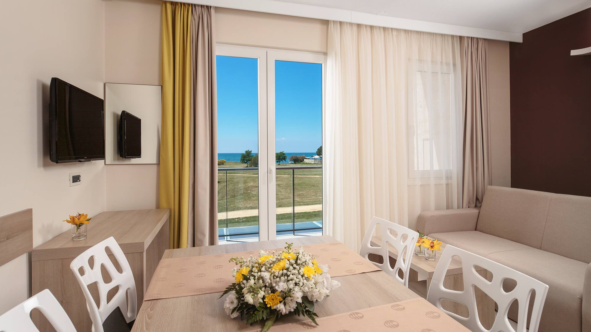 a room with a table and chairs and a television