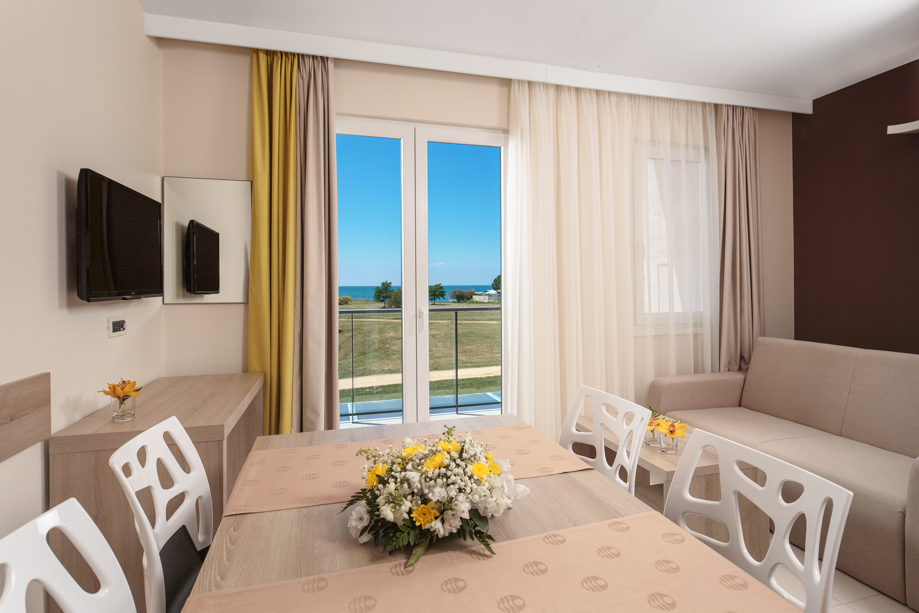 a room with a table and chairs and a television
