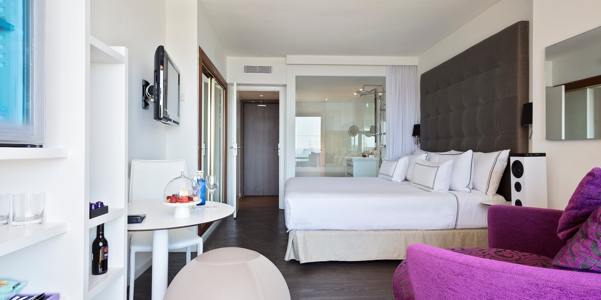 a room with a bed and purple chairs