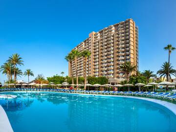 a pool with lounge chairs and a building in the background