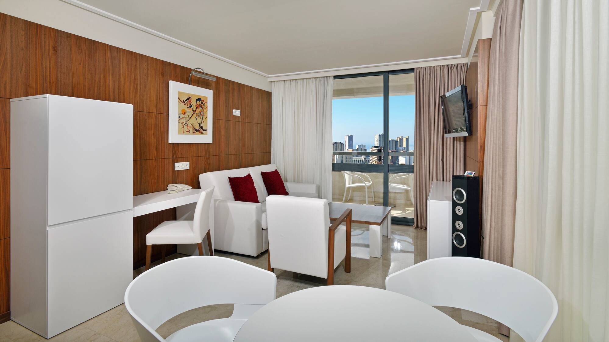 a room with white furniture and a television