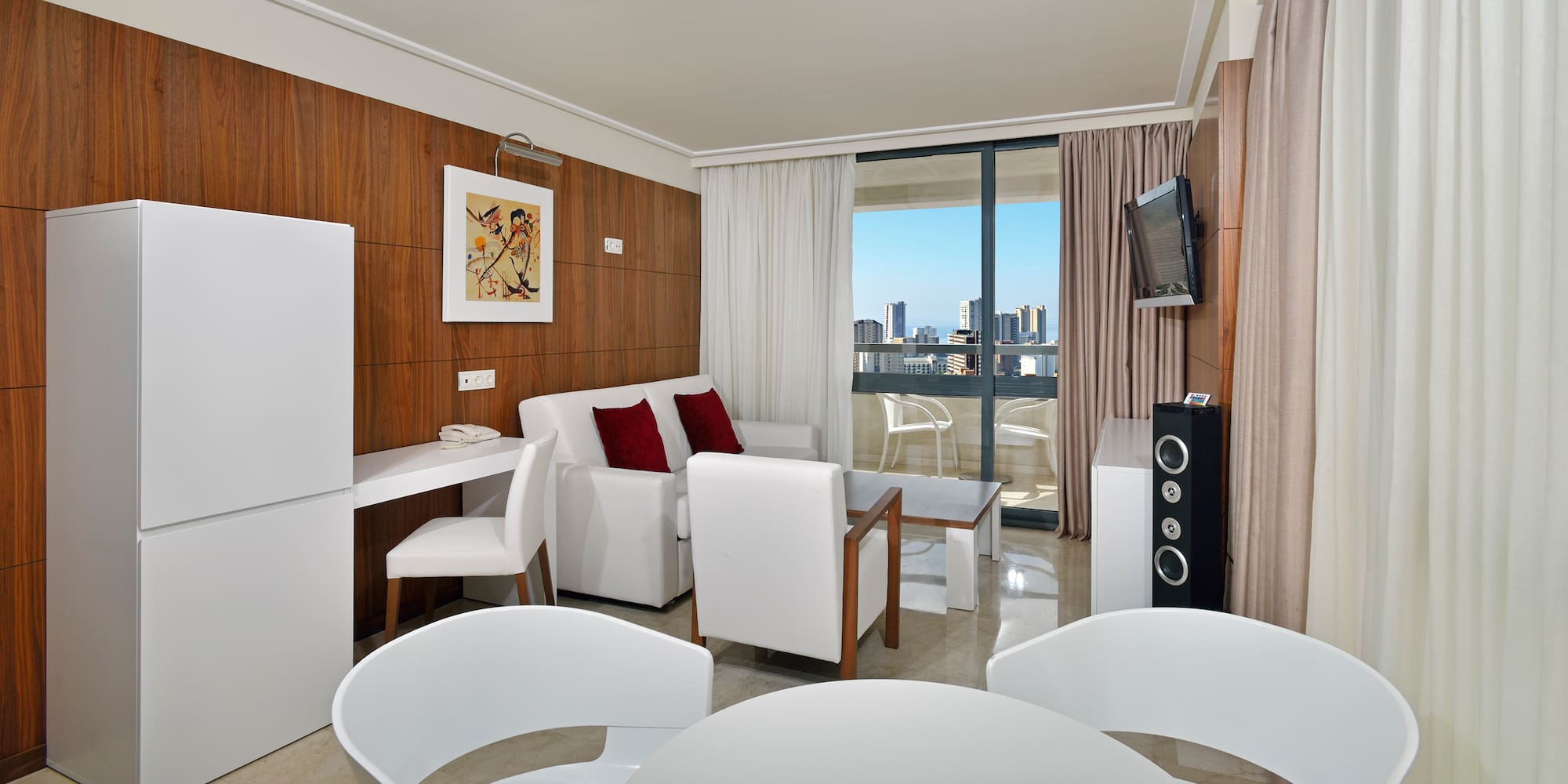 a room with white furniture and a television