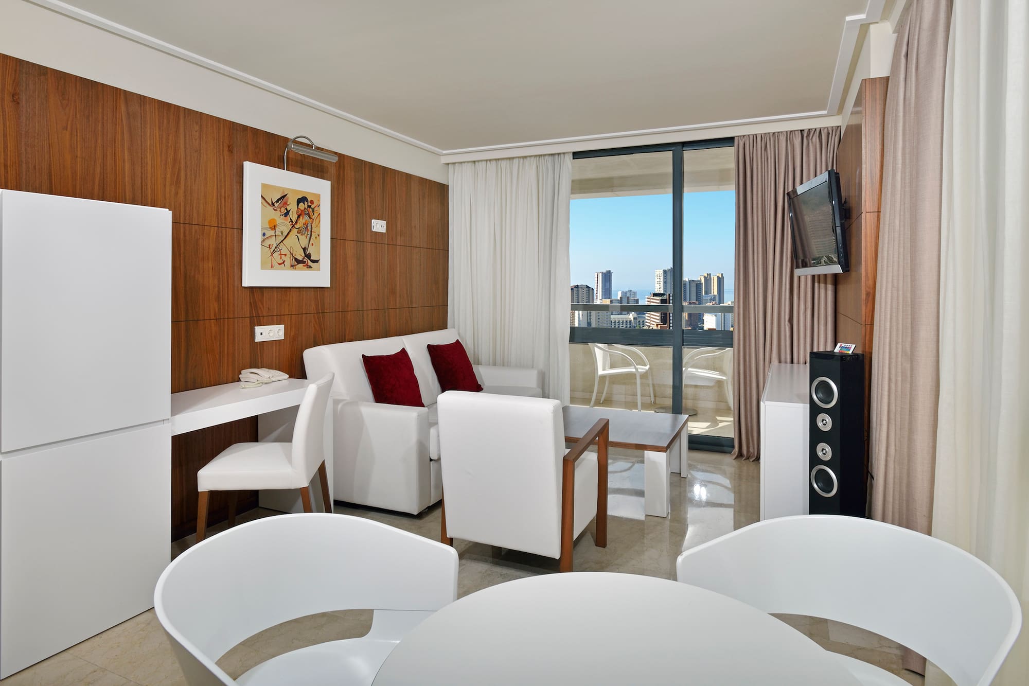 a room with white furniture and a television