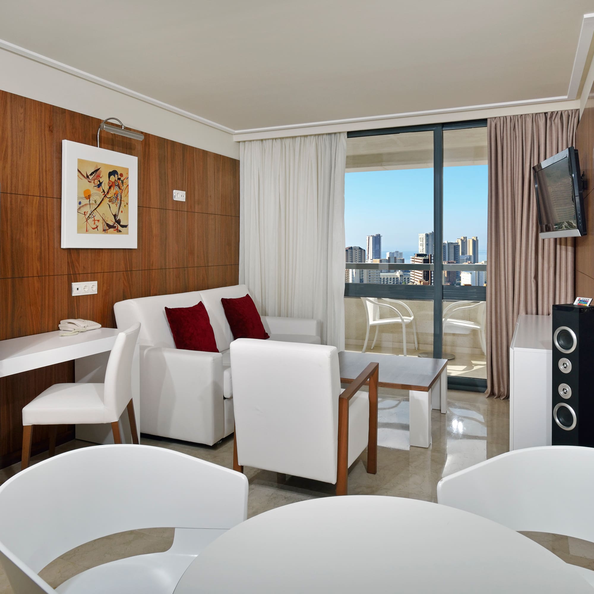 a room with white furniture and a television