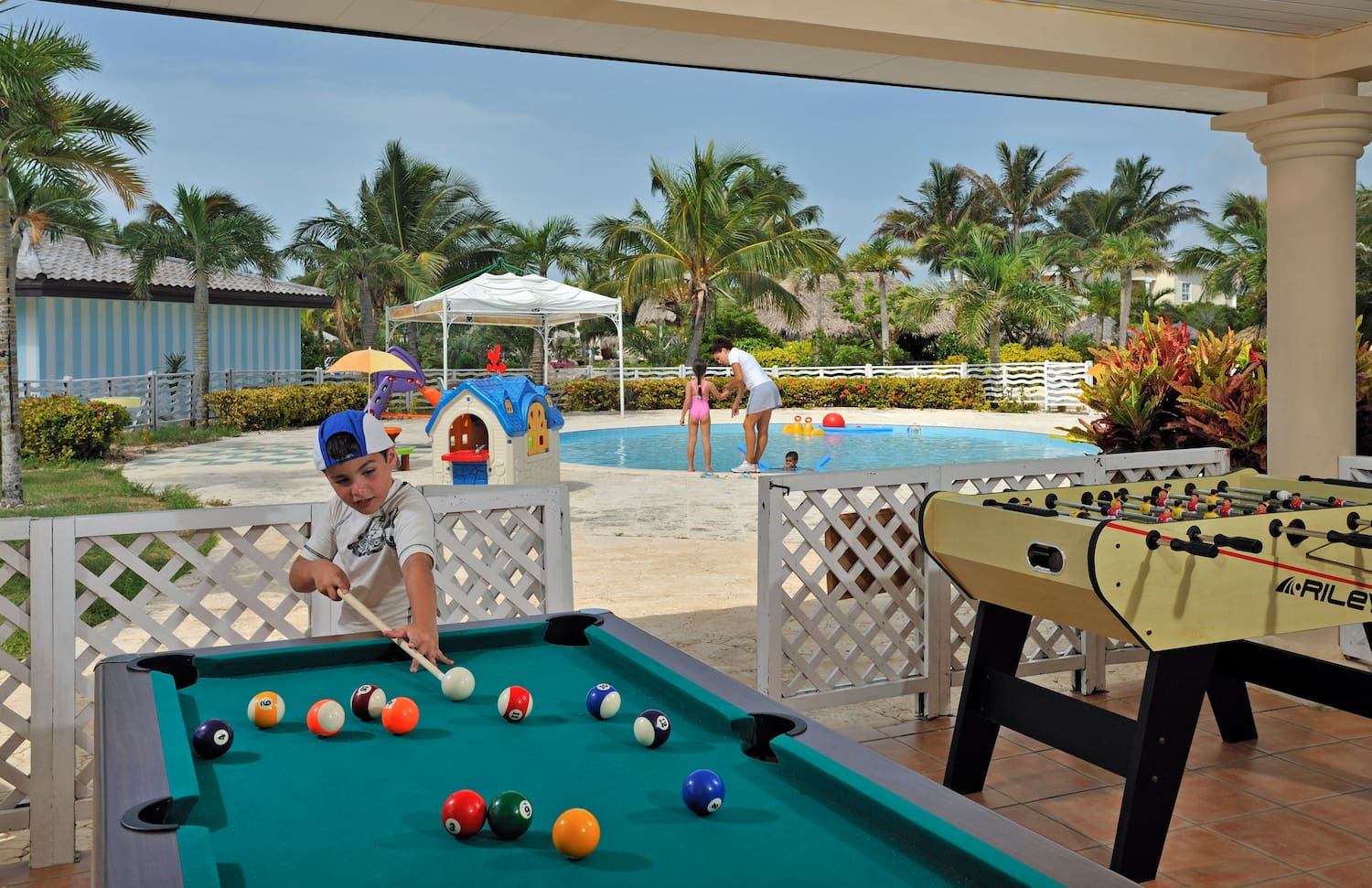 a boy playing pool with a pool table