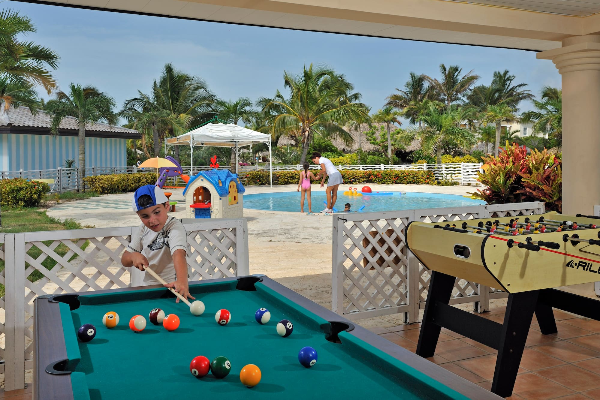 a boy playing pool with a pool table