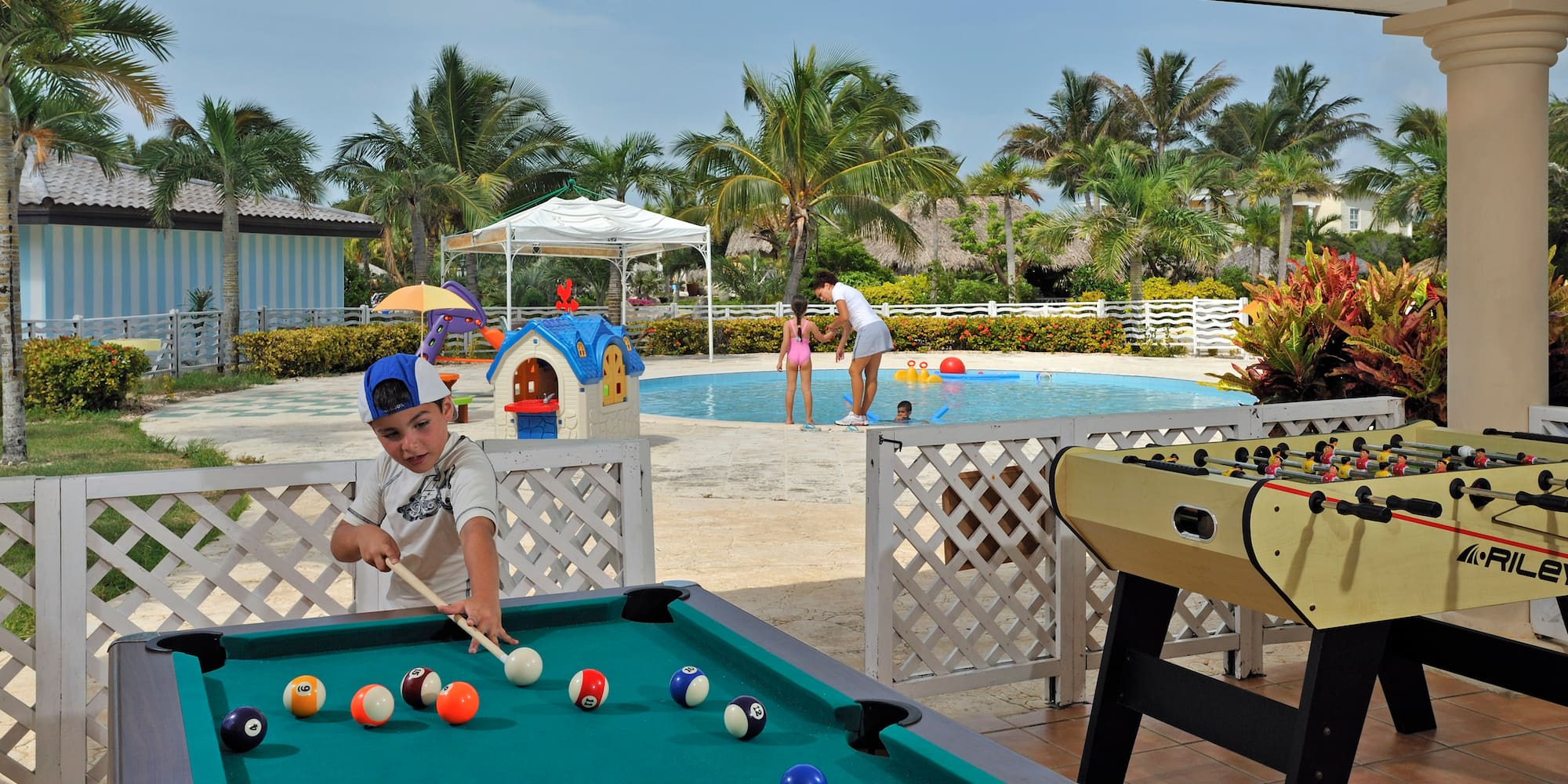 a boy playing pool with a pool table