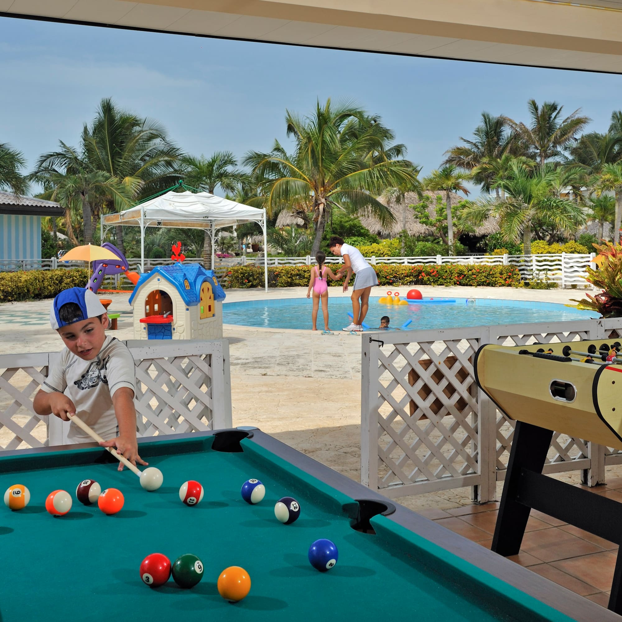 a boy playing pool with a pool table