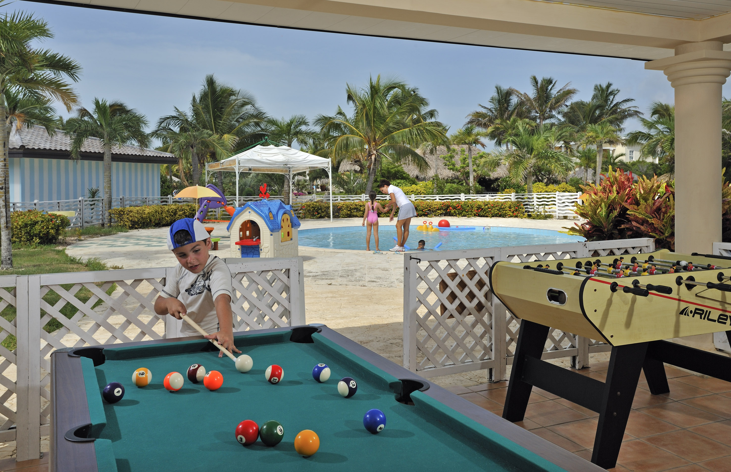 a boy playing pool with a pool table