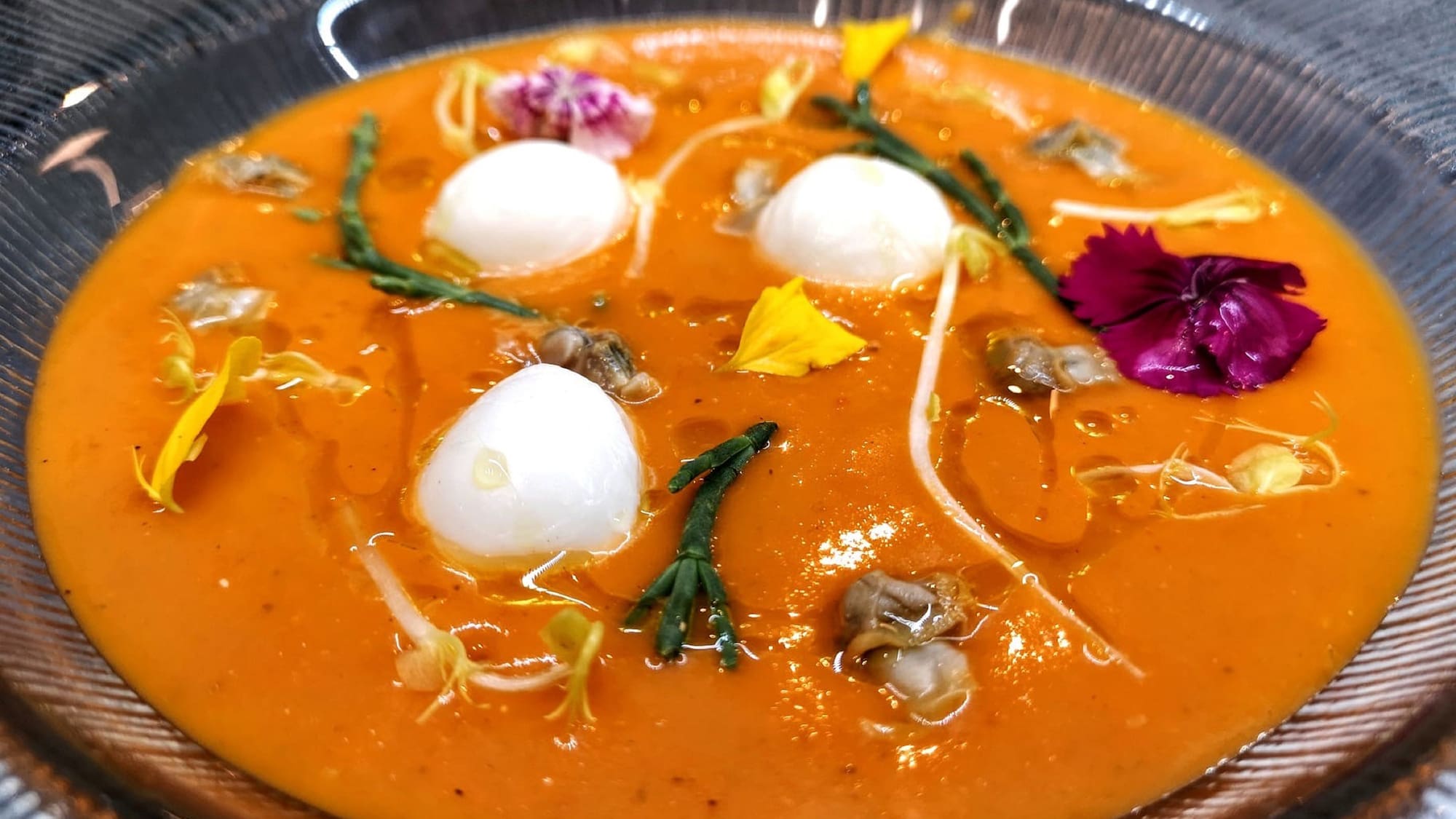 a bowl of soup with flowers and eggs