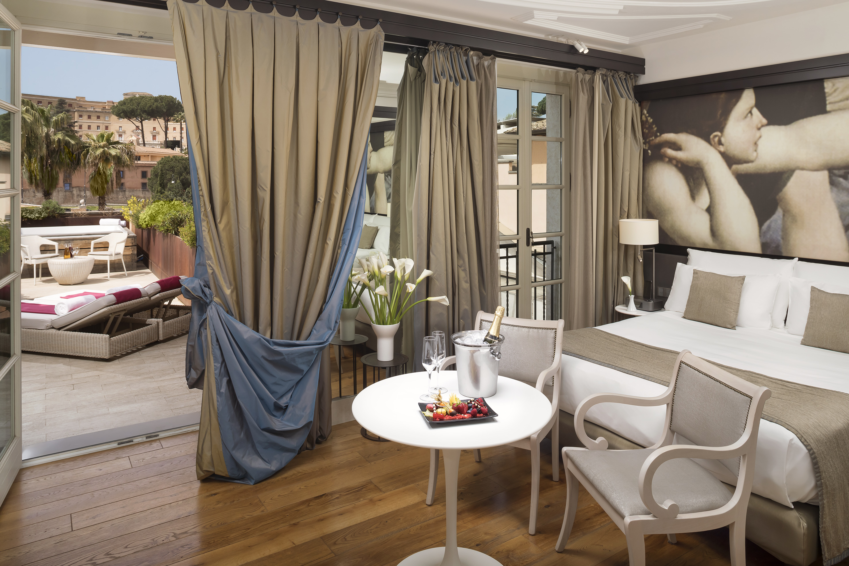 Luxury hotel suite with private terrace, king bed, and welcome amenities.