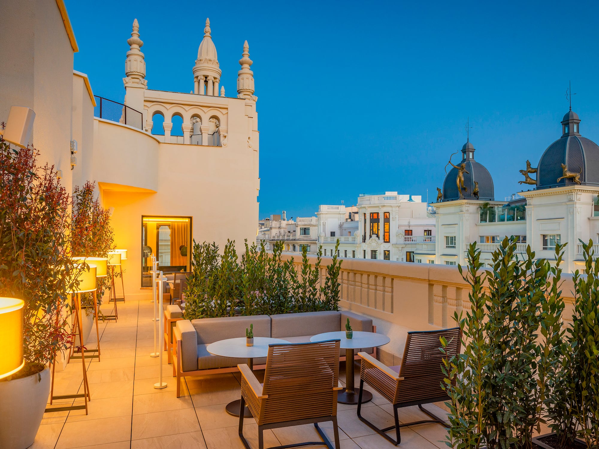 a patio with tables and chairs on a rooftop