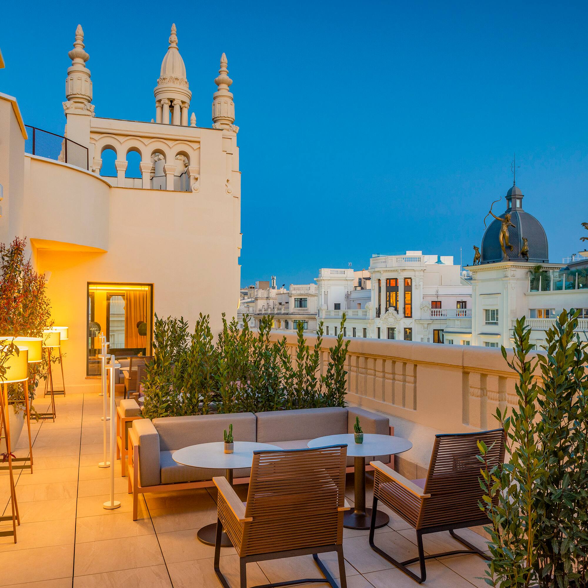 a patio with tables and chairs on a rooftop