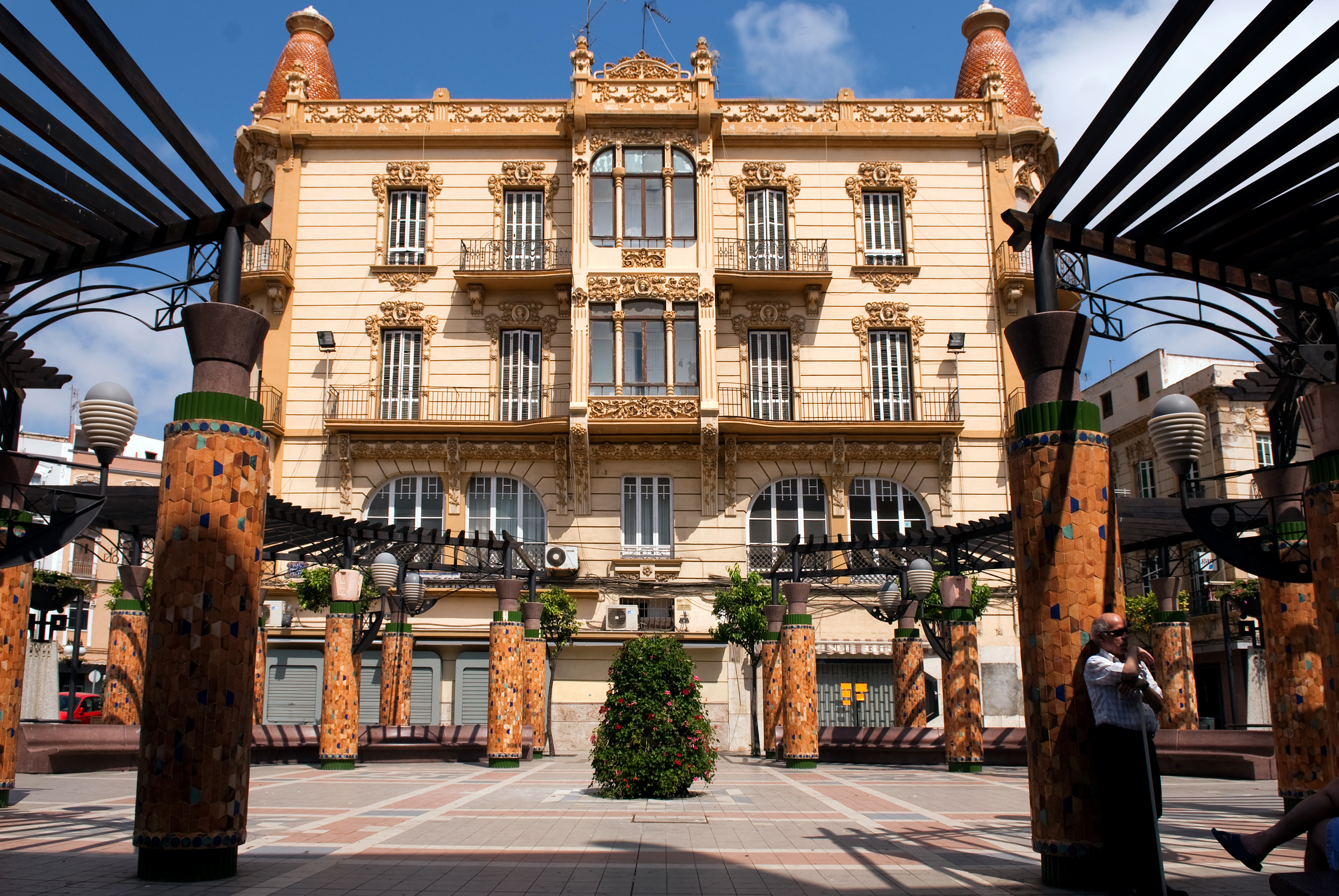 a building with columns and a tree in the middle