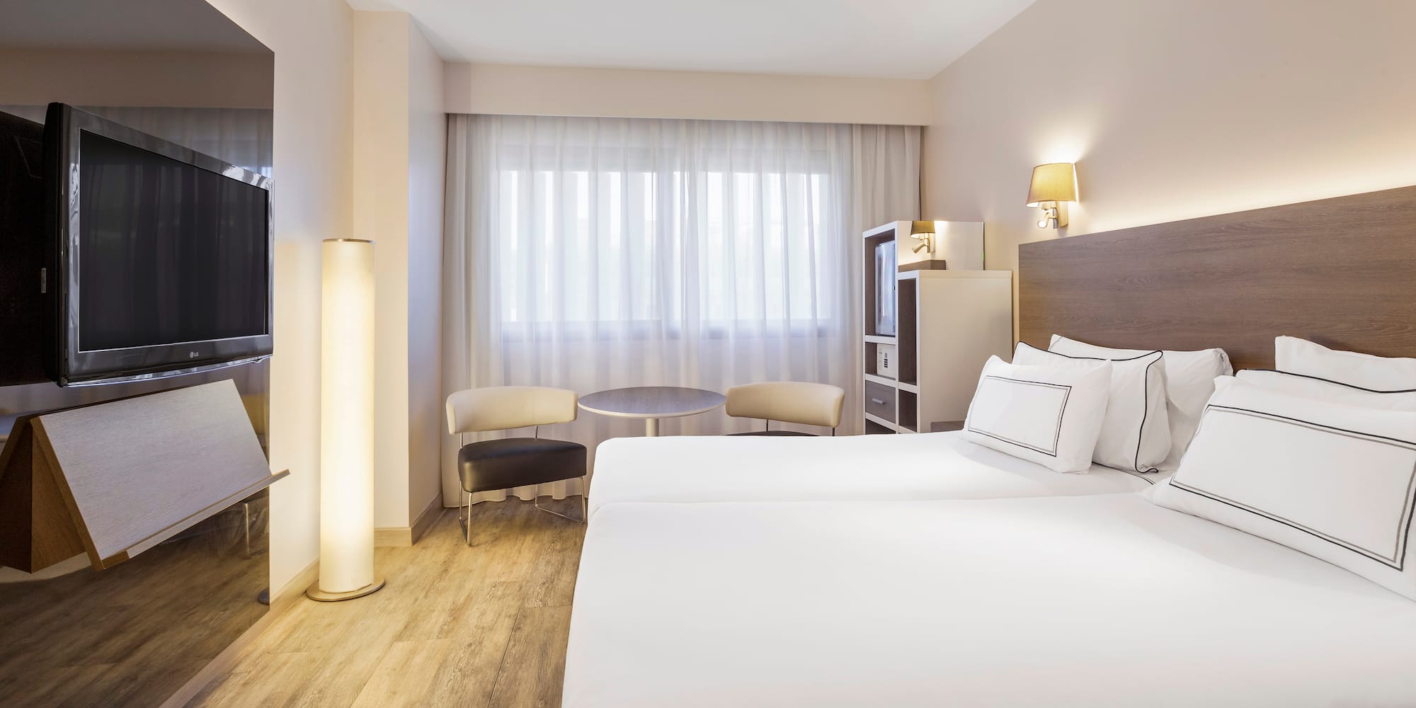 a room with two beds and a television