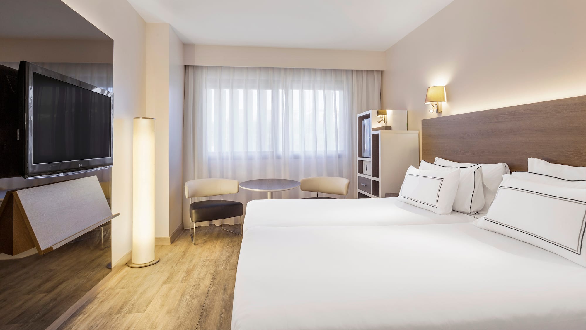 a room with two beds and a television