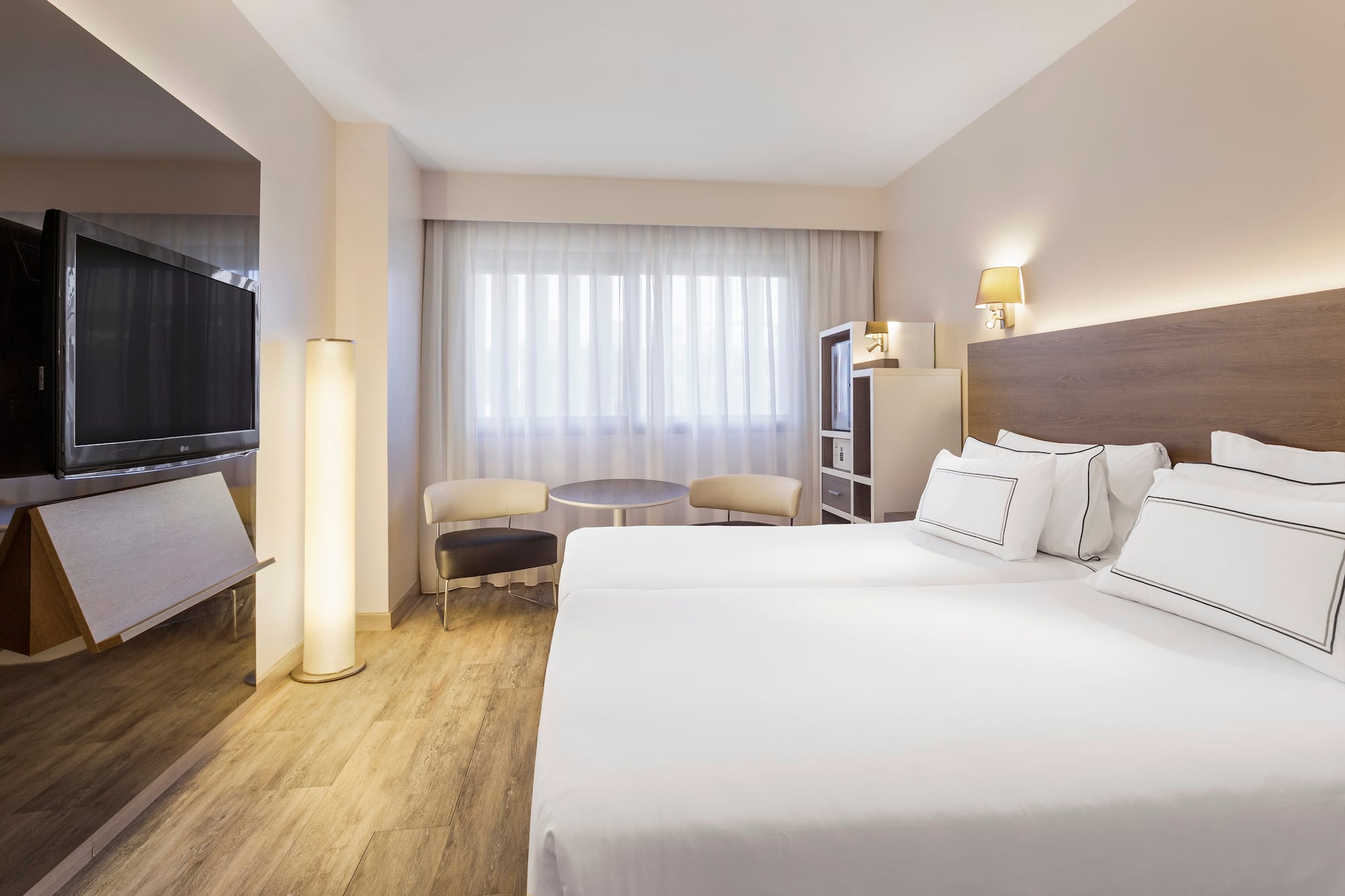 a room with two beds and a television