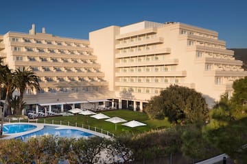 a large building with a pool and trees