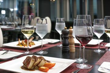 a table with plates of food and wine glasses