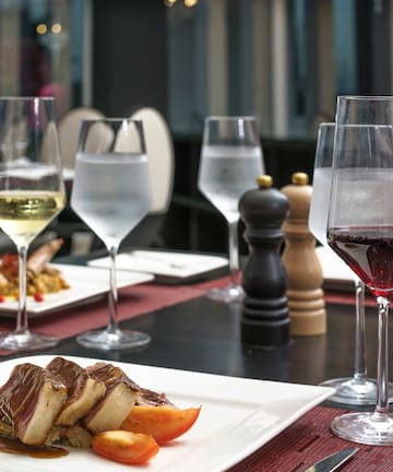 a table with plates of food and wine glasses