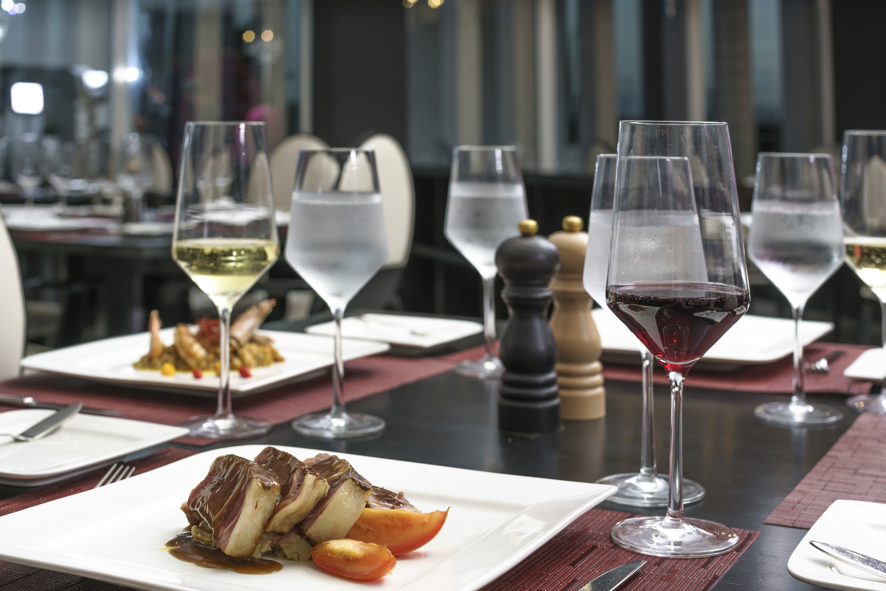 a table with plates of food and wine glasses