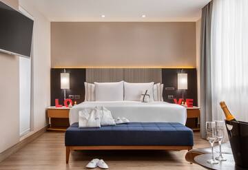 a bedroom with a bed and a blue ottoman