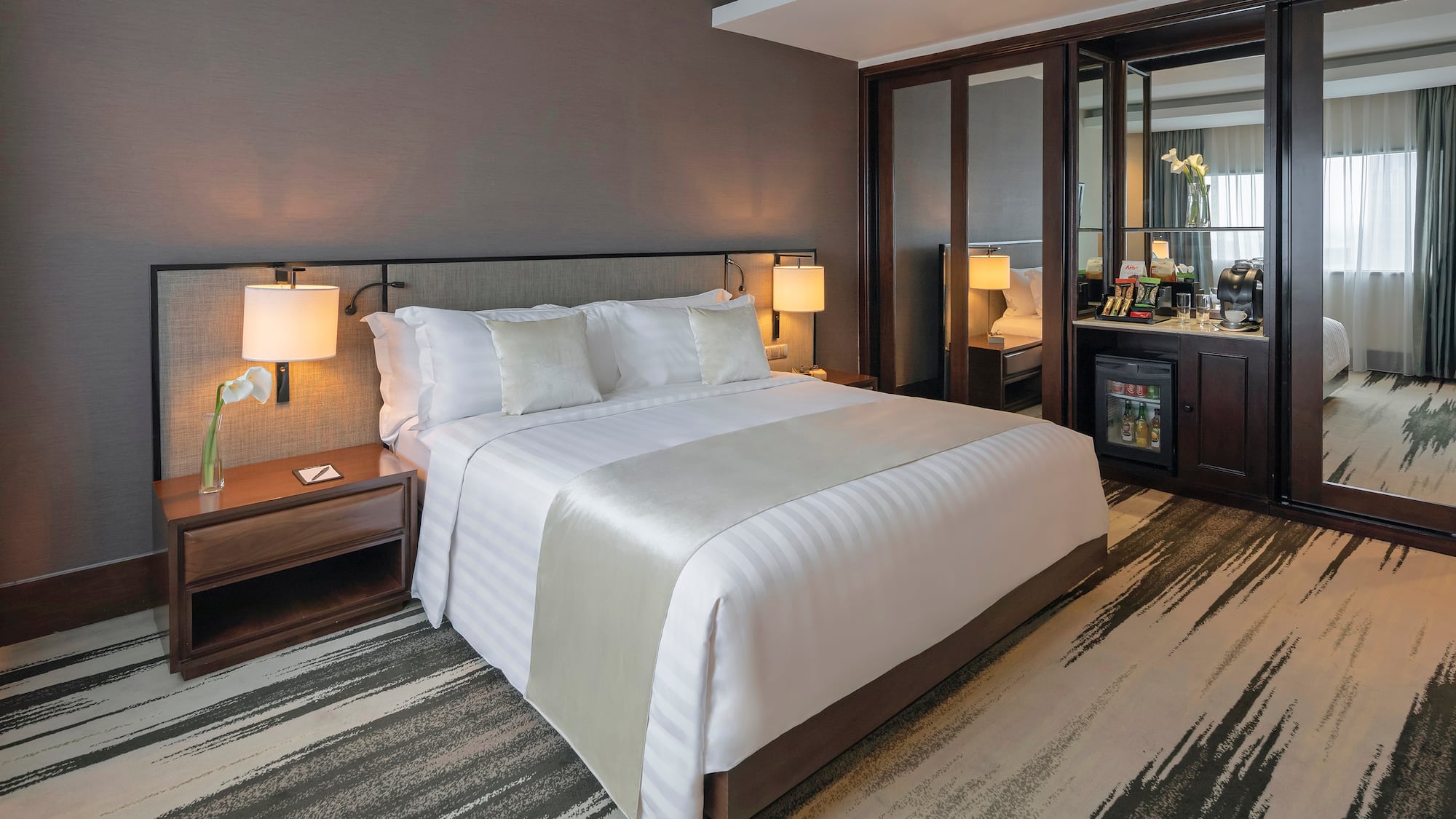 a hotel room with a bed and a mirror