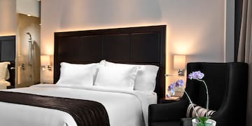 a bed with a black headboard and a chair