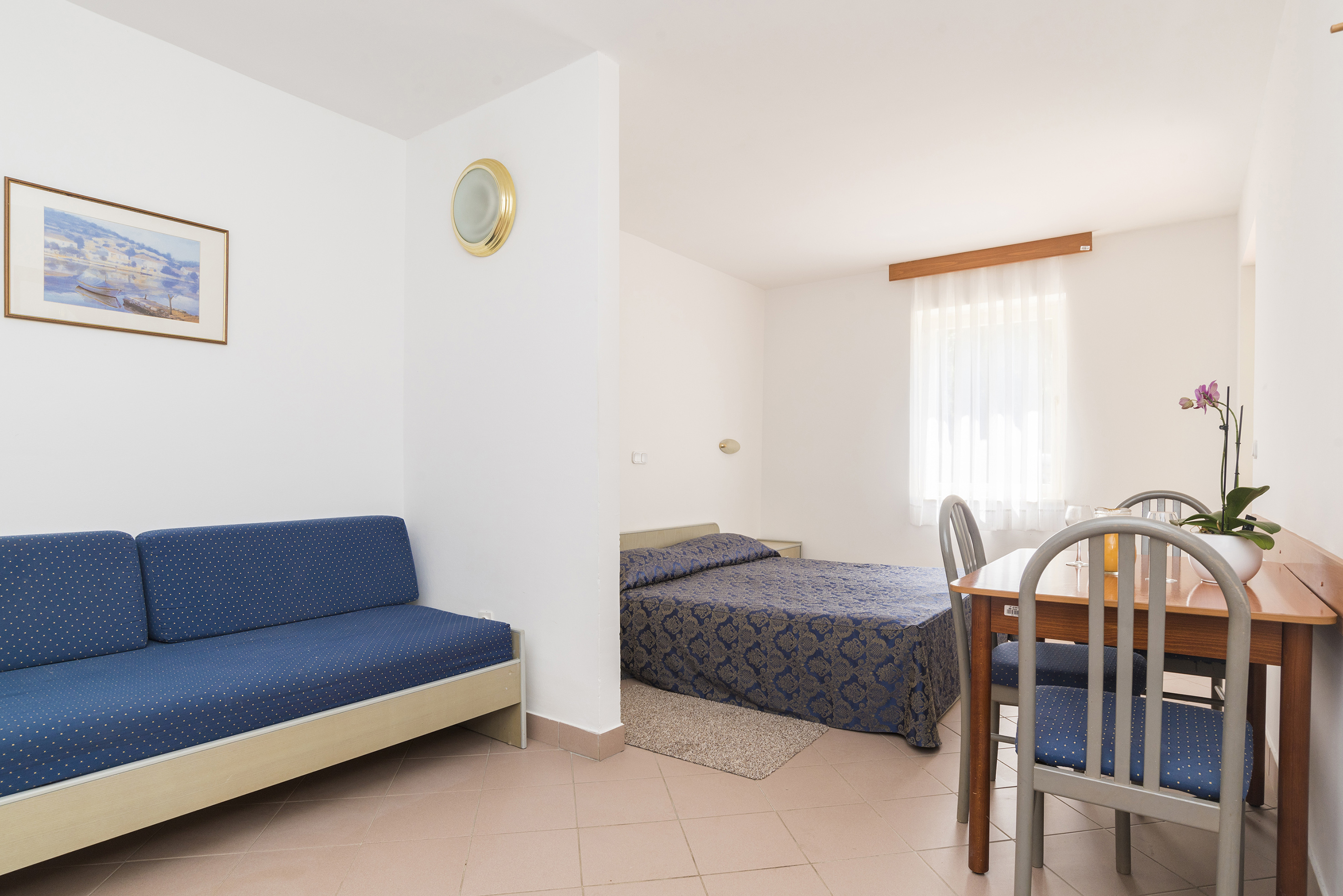 a room with a table and two beds