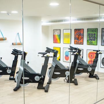 a room with exercise bikes and art on the wall