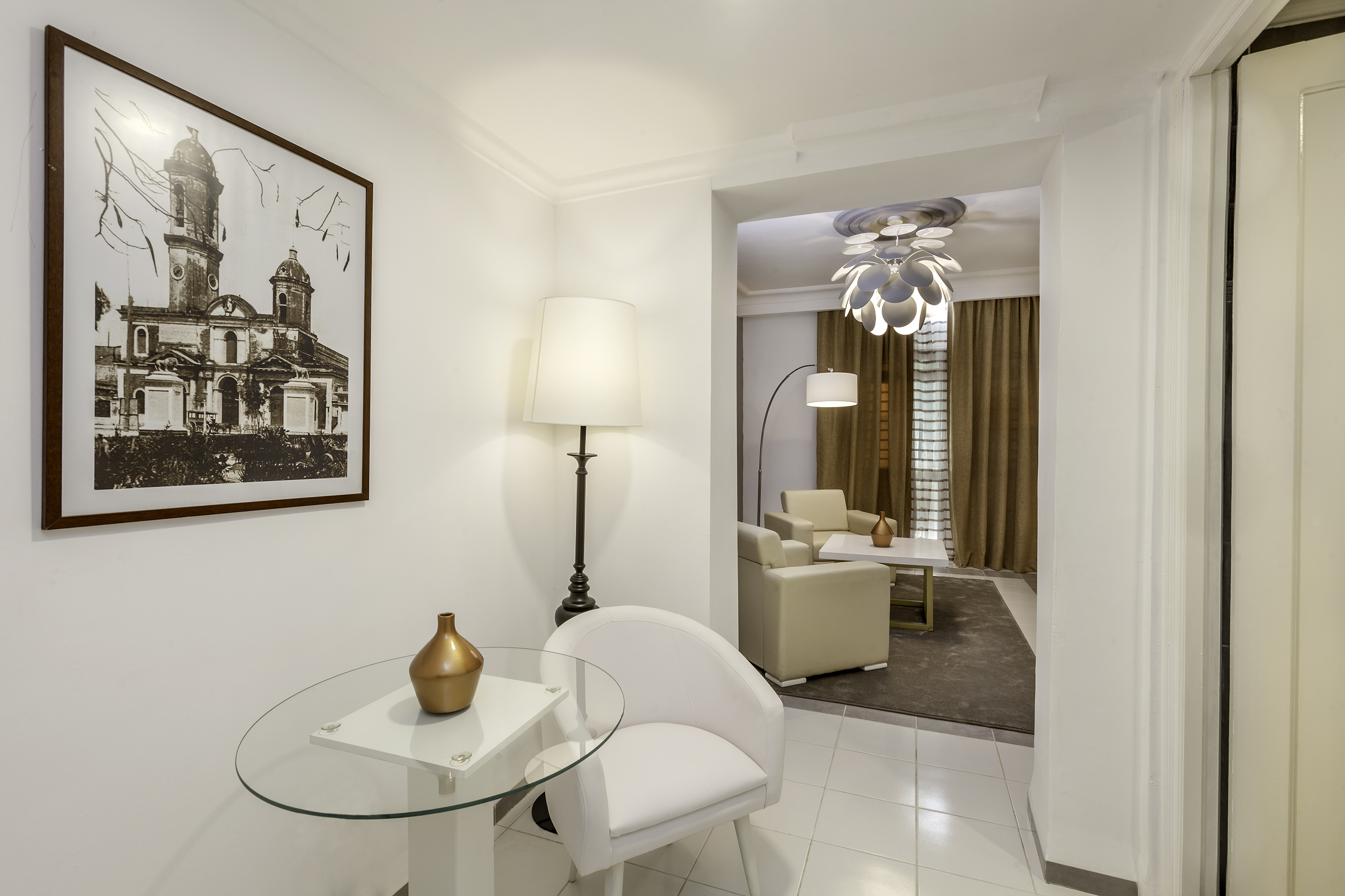 a room with a glass table and a lamp