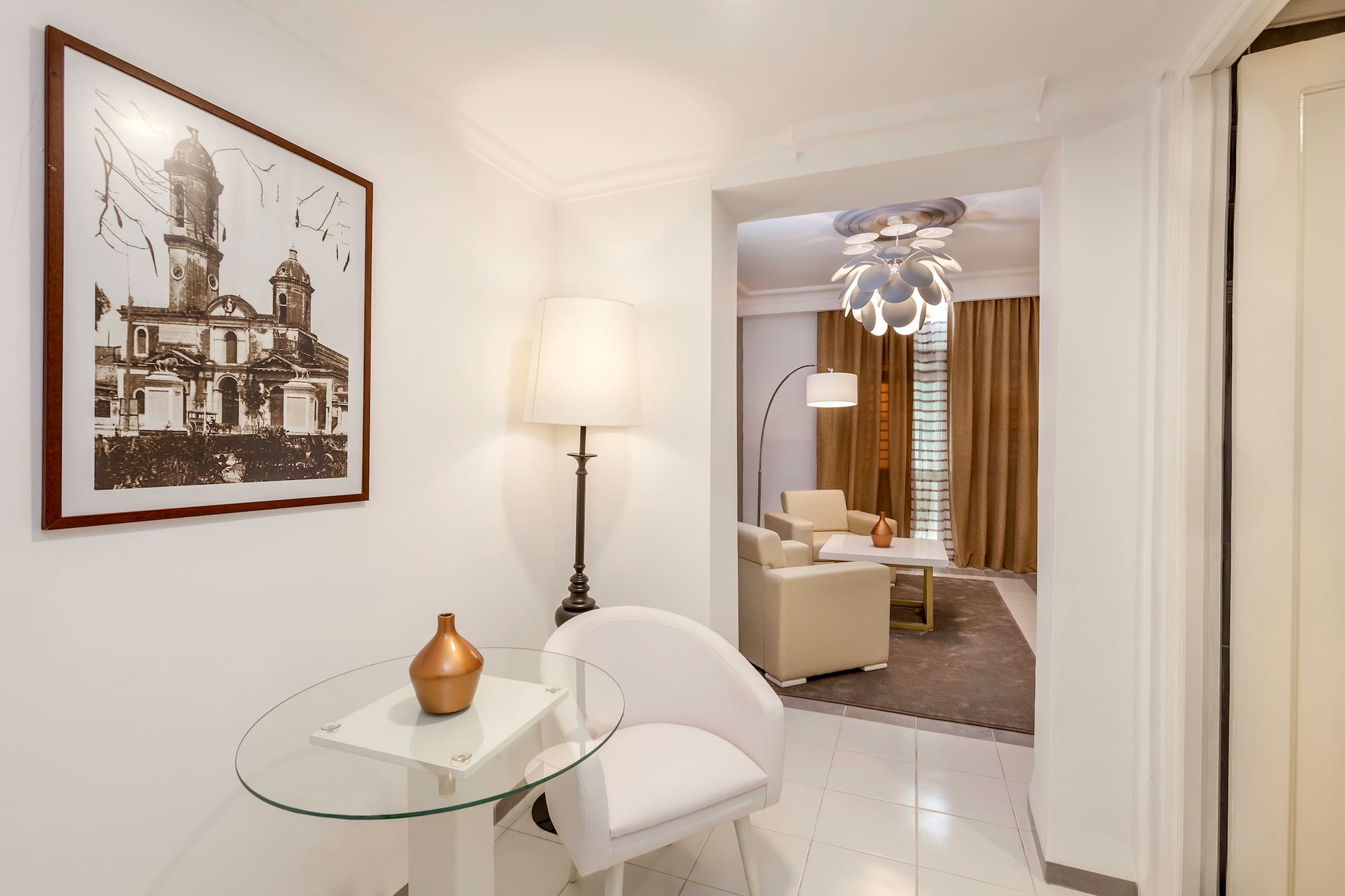 a room with a glass table and a lamp