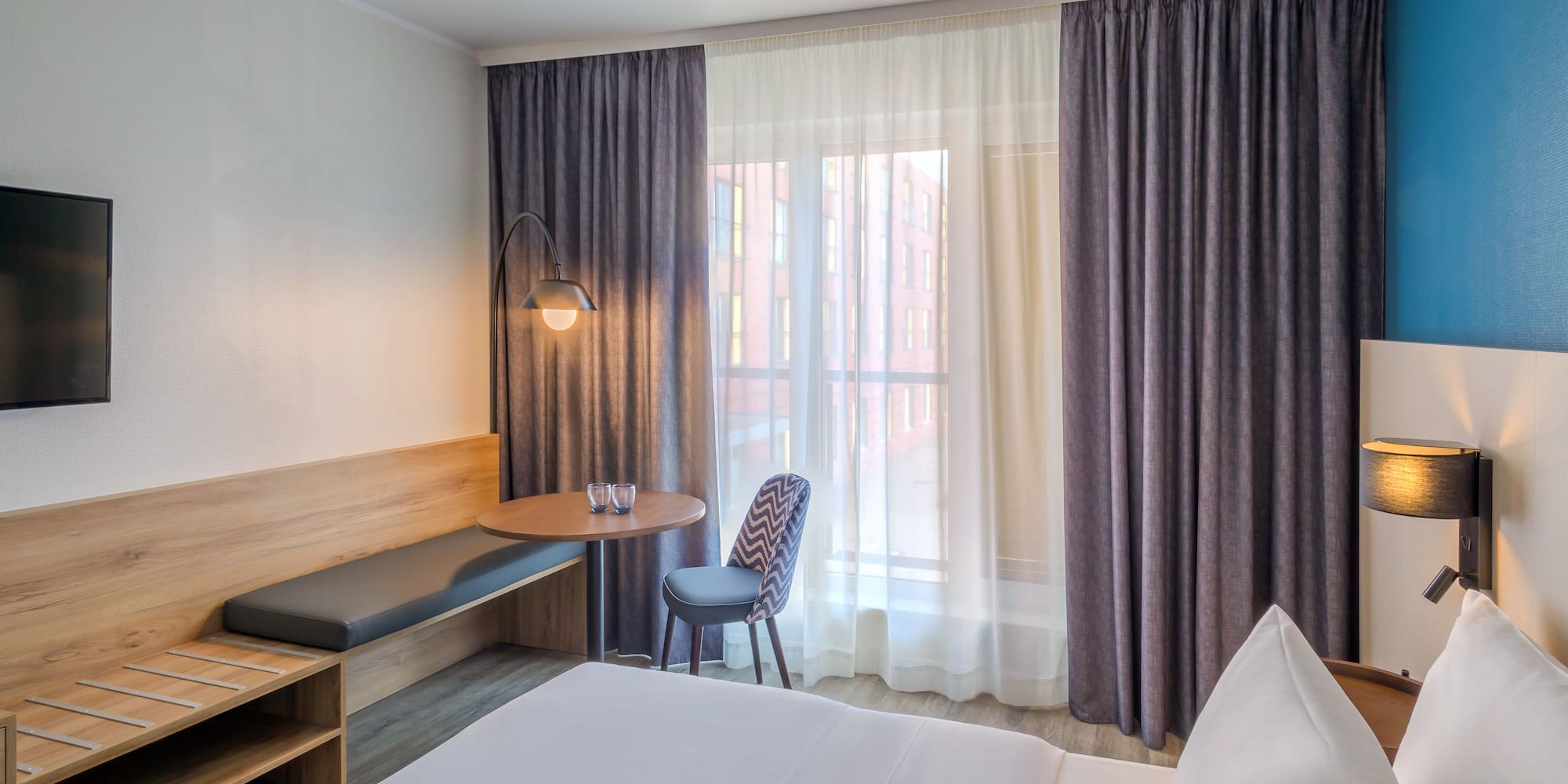 a room with a bed and a table and chair