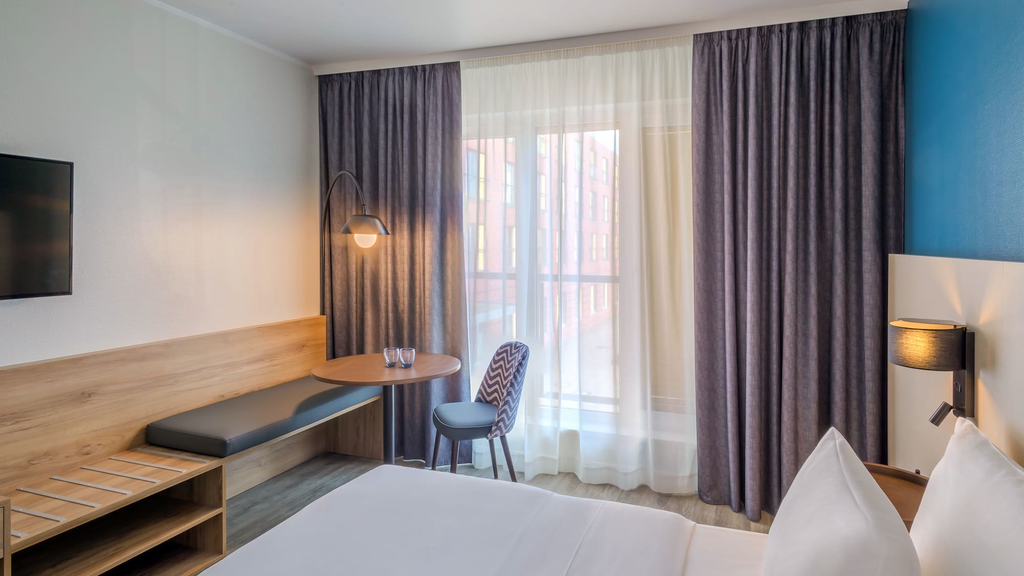 a room with a bed and a table and chair