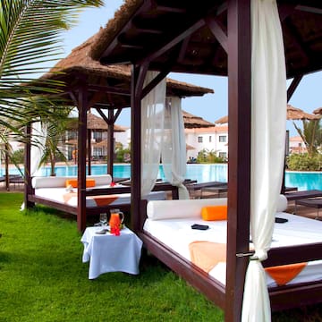 a bed and a table with a pool in the background