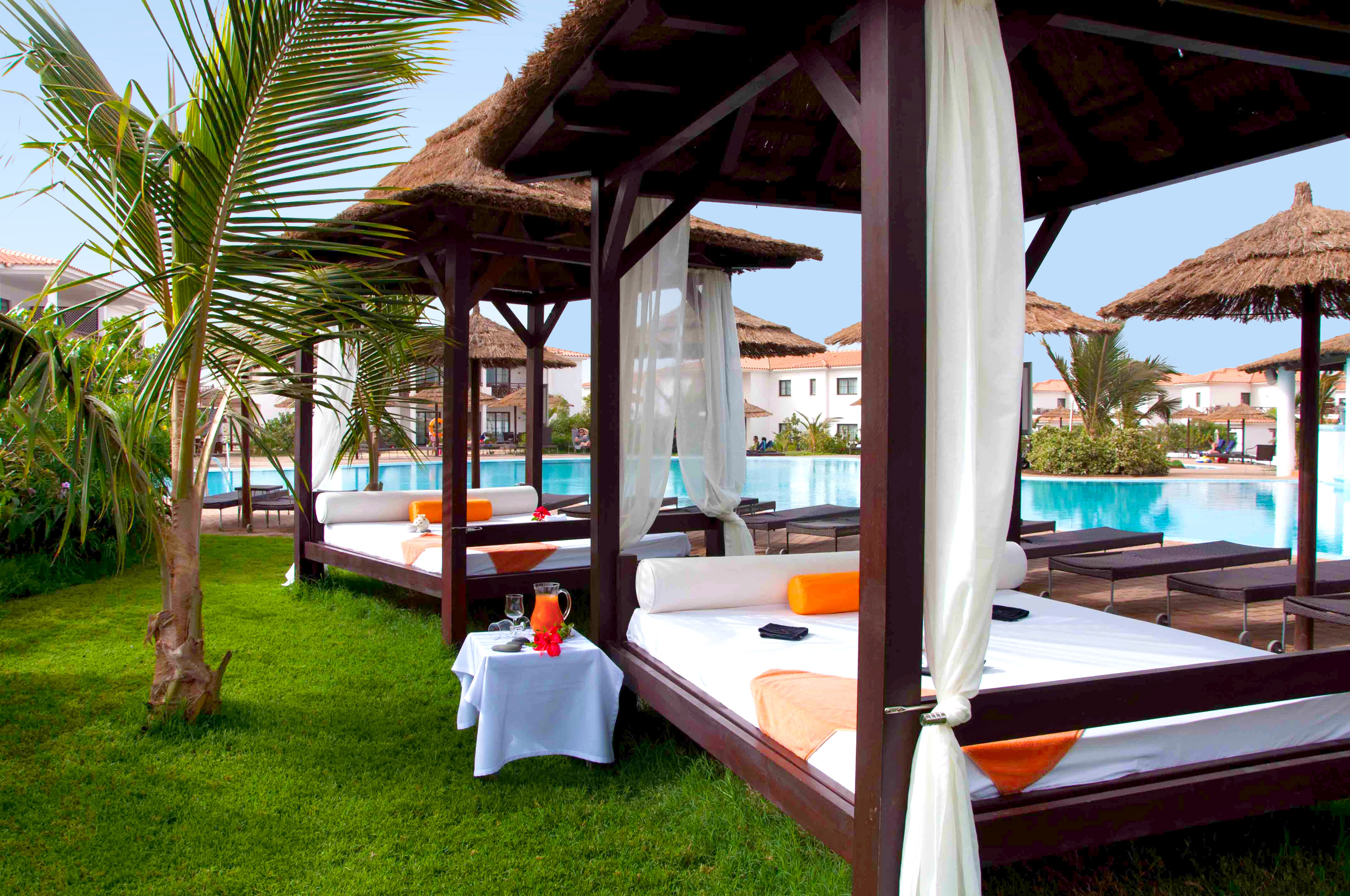 a bed and a table with a pool in the background