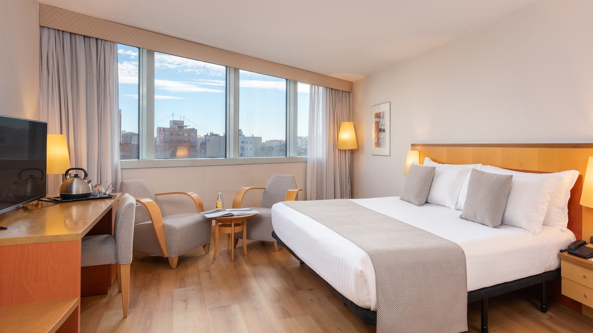 a room with a bed and chairs