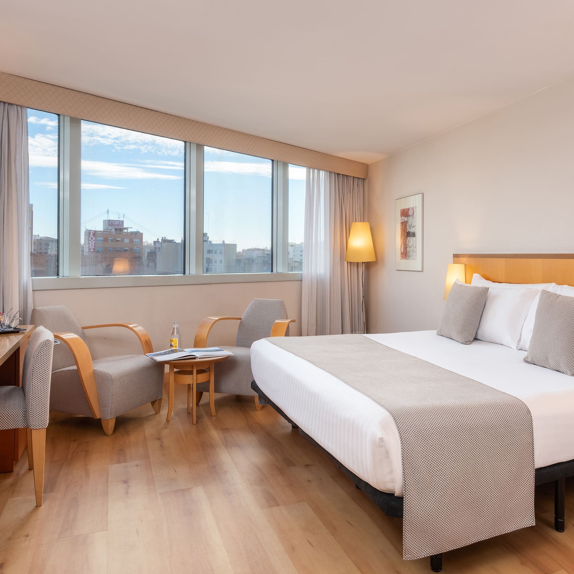 a room with a bed and chairs