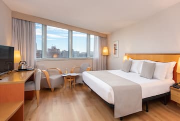 a room with a bed and chairs