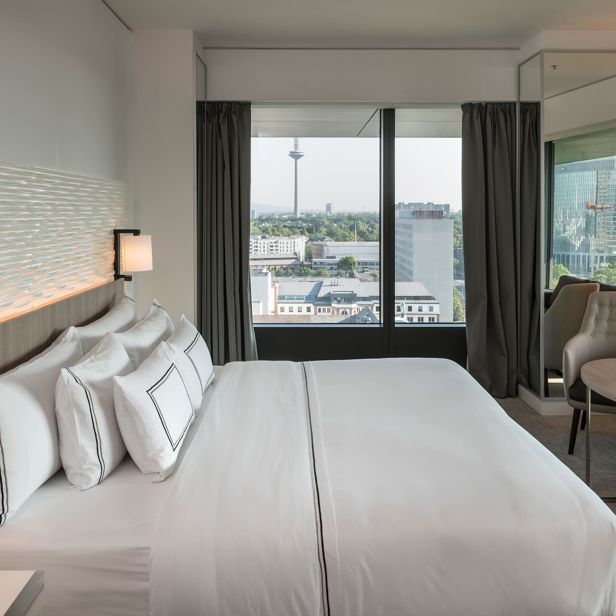 a hotel room with a large bed and a chair