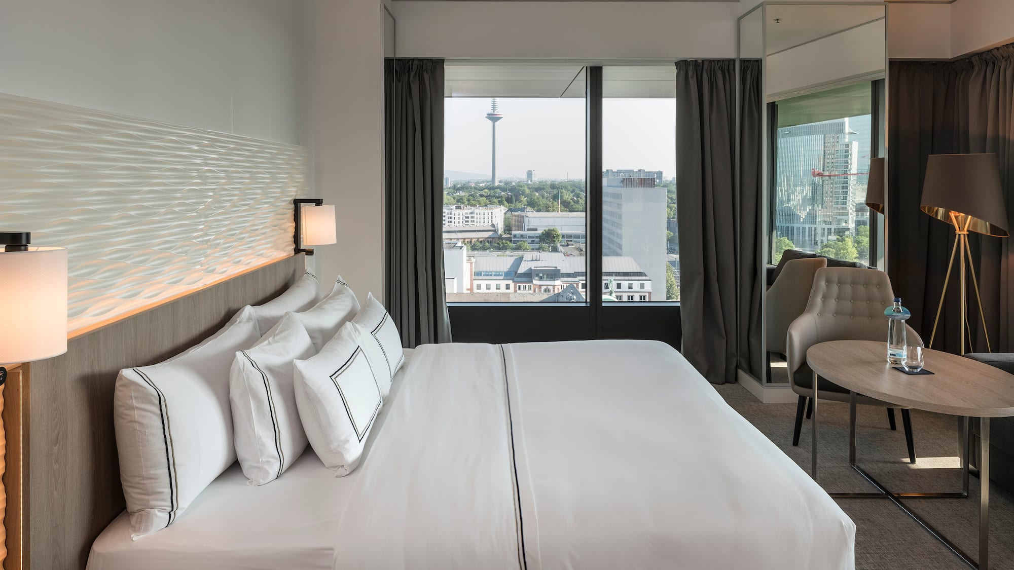 a hotel room with a large bed and a chair