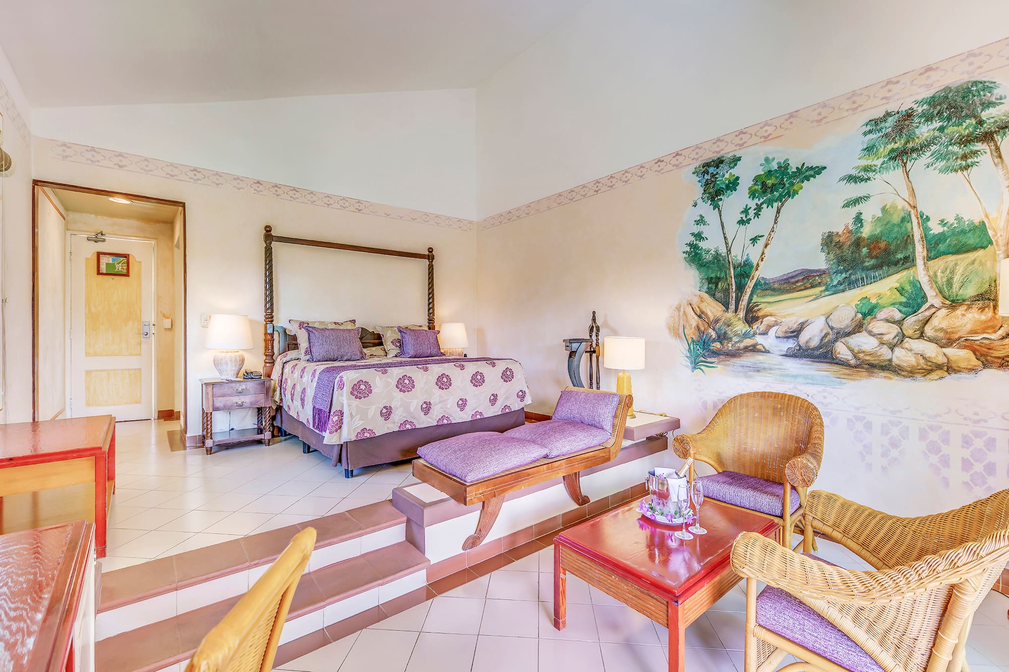 a room with a bed and chairs