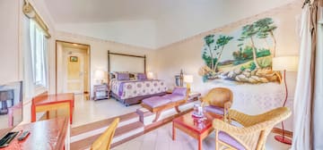 a room with a bed and chairs