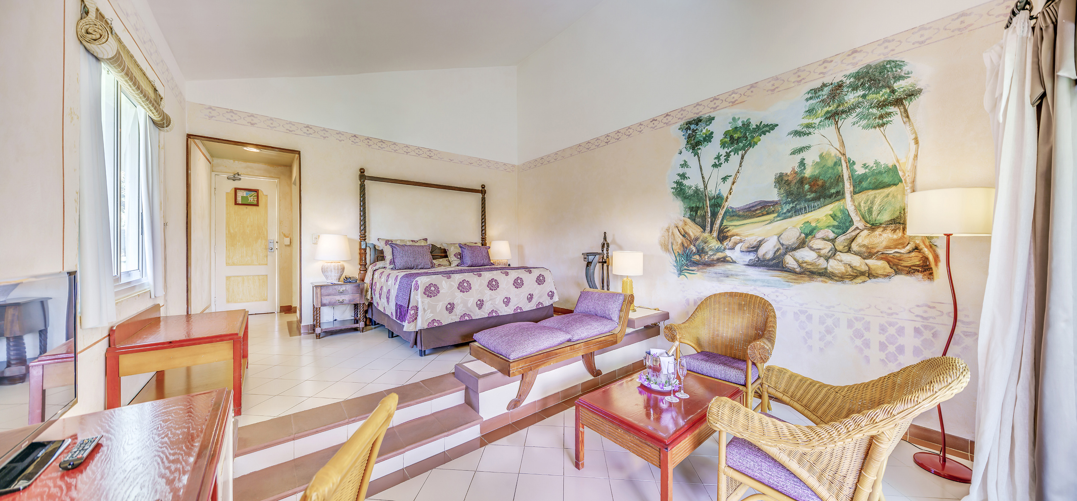 a room with a bed and chairs