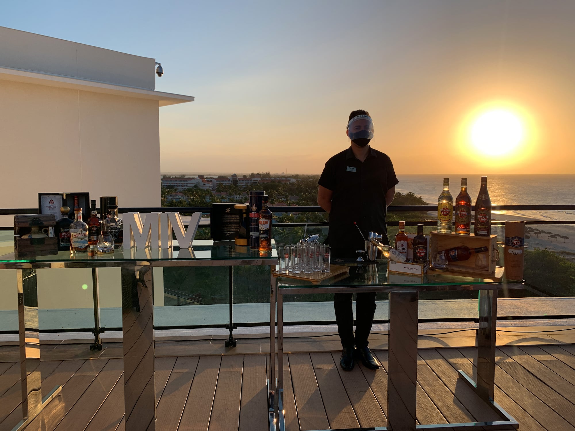 a man standing in front of a table with bottles and alcohol on it