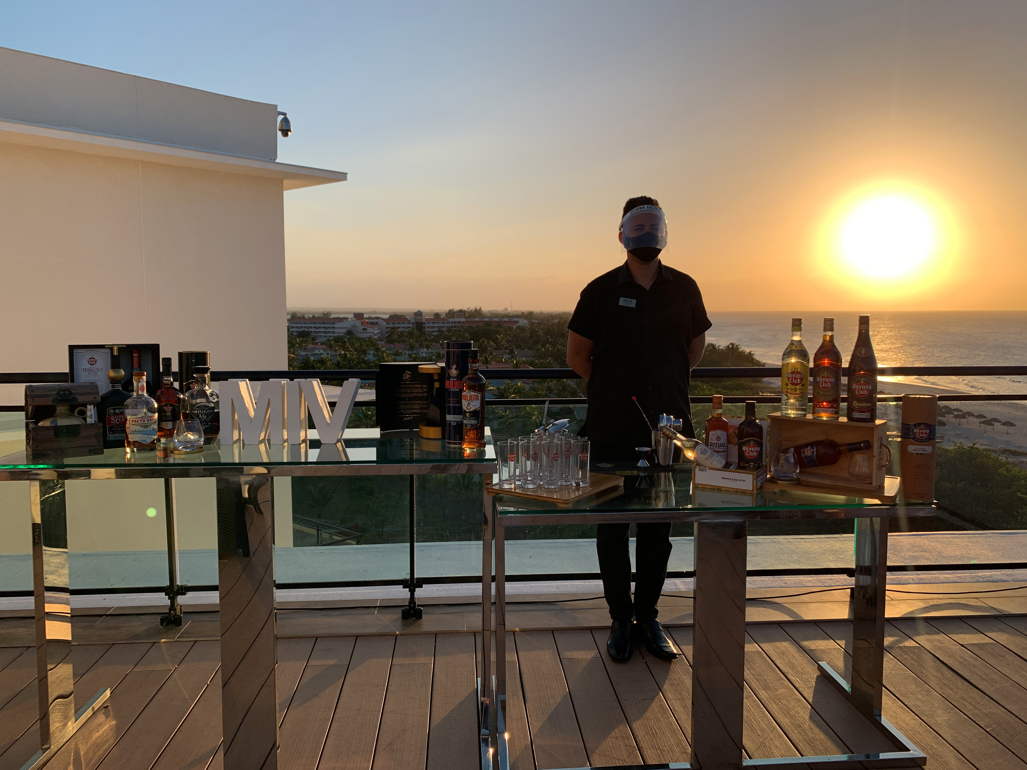 a man standing in front of a table with bottles and alcohol on it