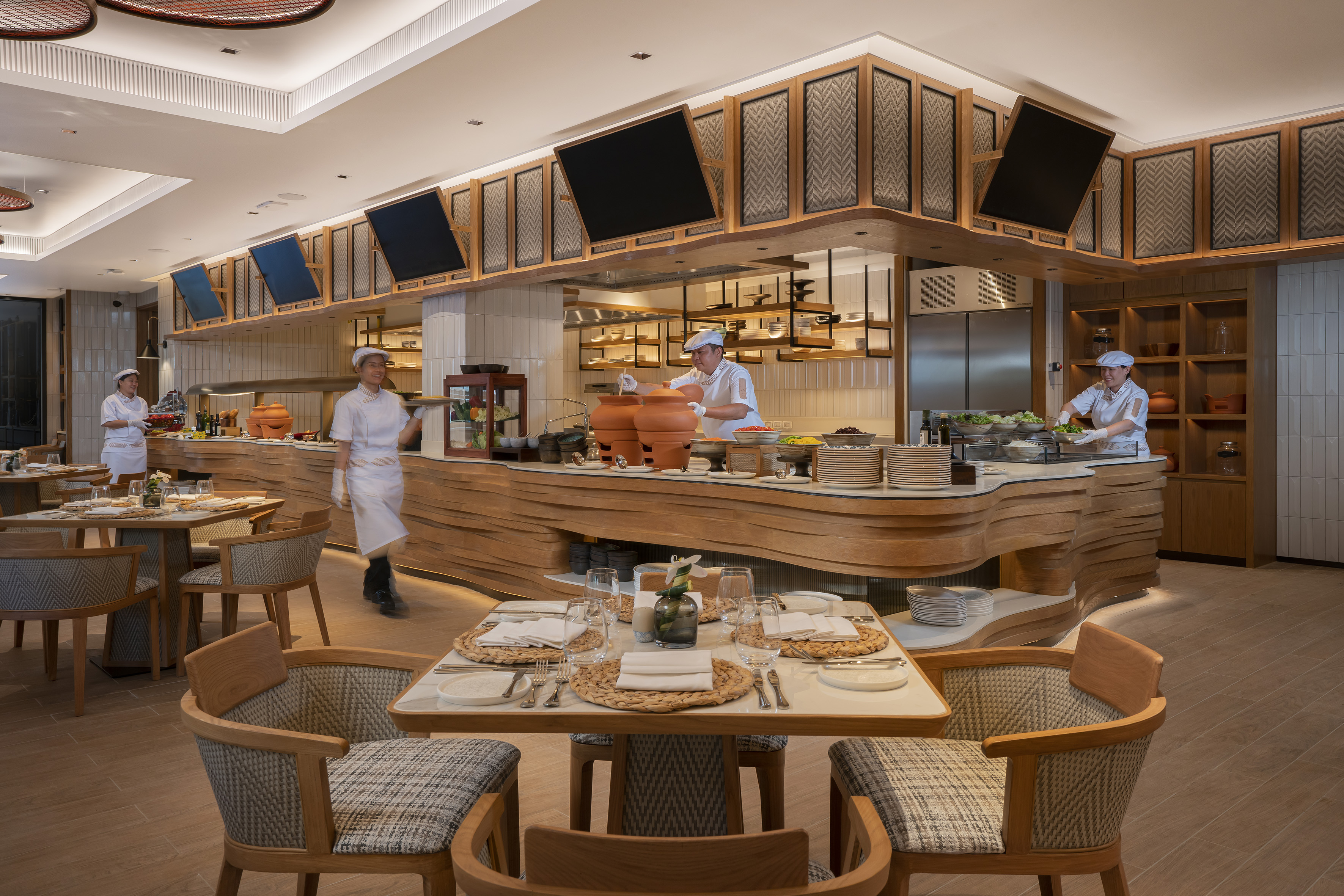 Stylish restaurant buffet with chefs, open kitchen, and fresh food display.