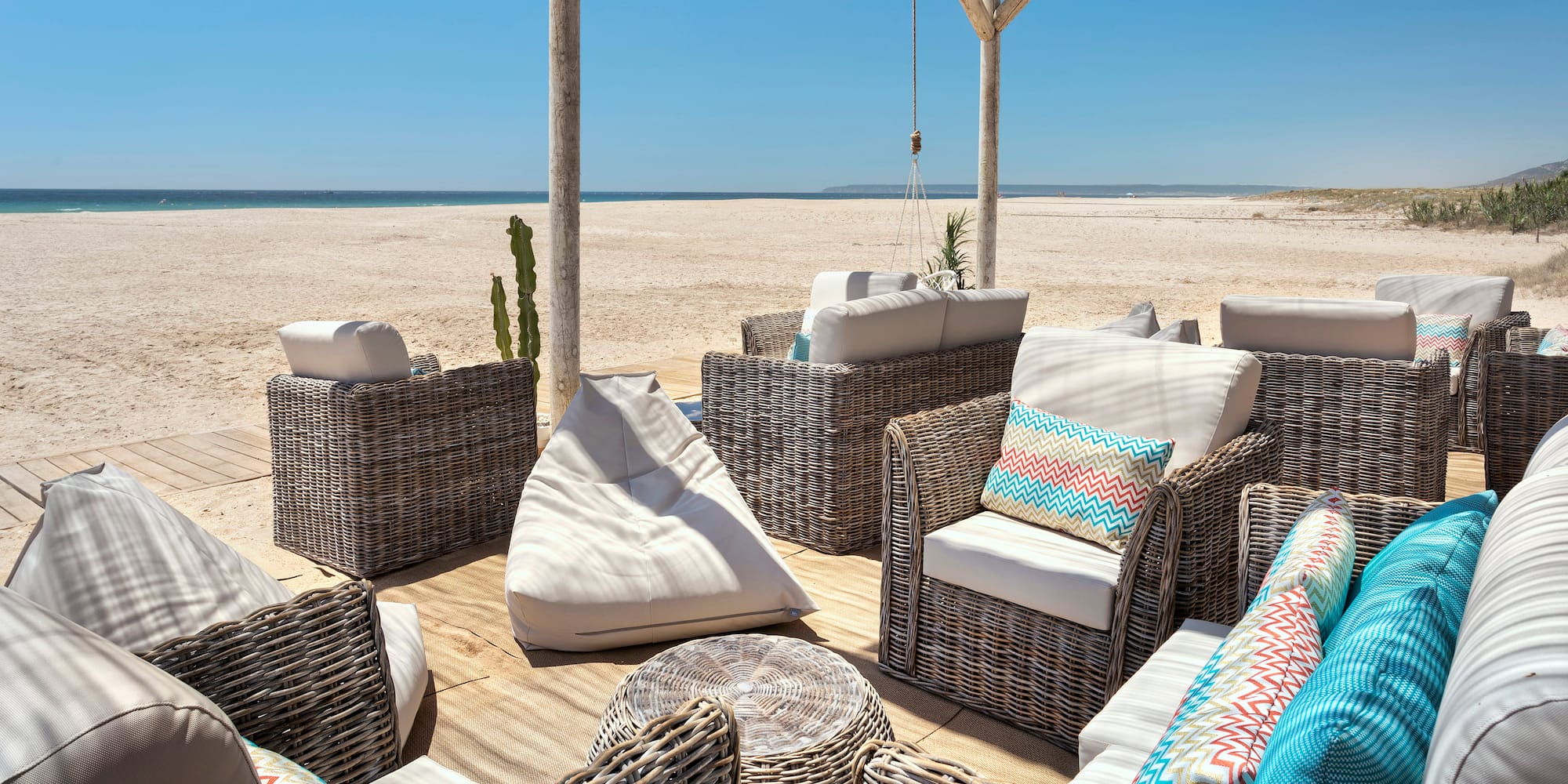 a group of wicker chairs on a beach